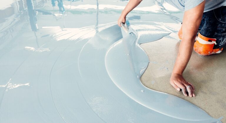 Construction,Worker,Spreading,Self-leveling,Concrete,Mixture,Over,The,Floor,Using